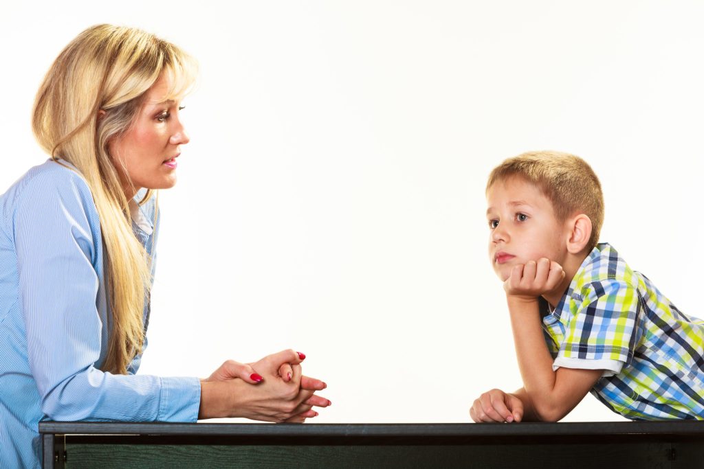Child pausing to think during a conversation with an adult