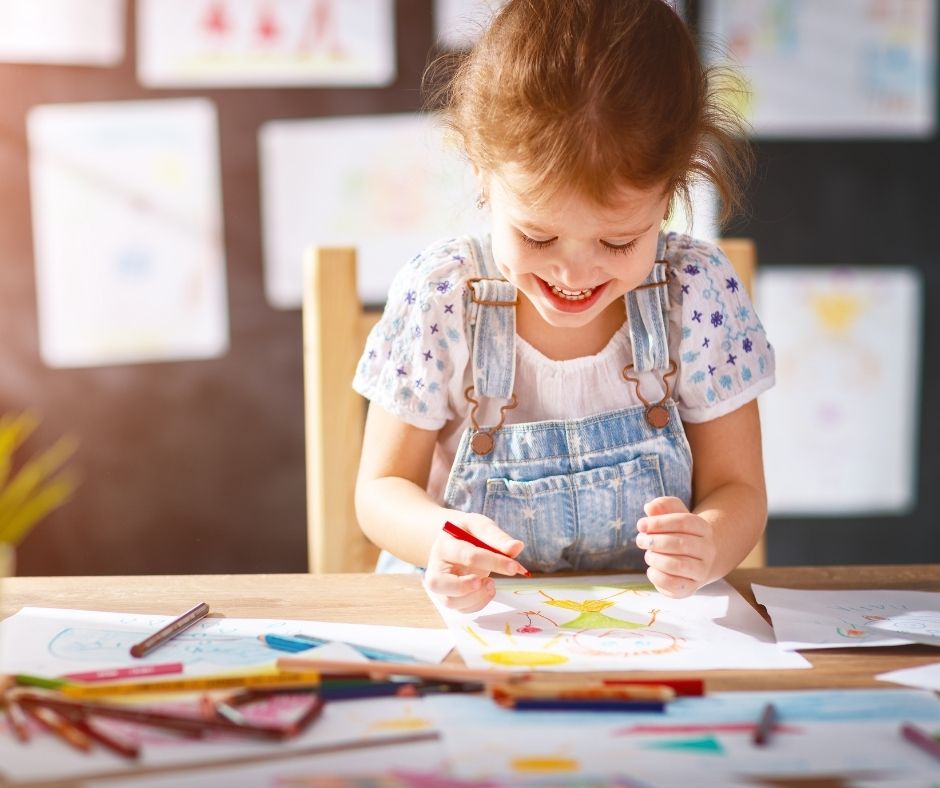Young child practicing drawing and early writing at home