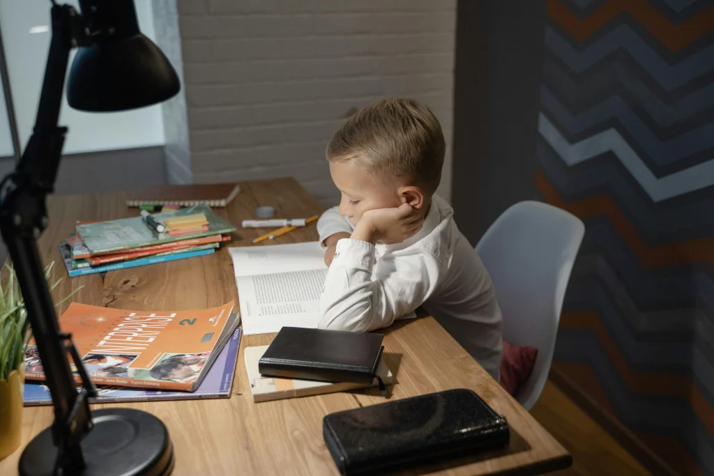 Child working in a familiar home study place with materials ready