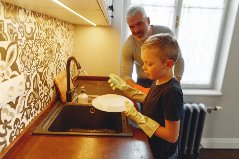 Parent helping a child with a simple household chore in a predictable daily routine