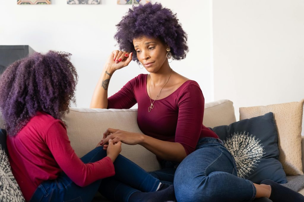 Parent speaking steadily to a child during an emotional conversation at home