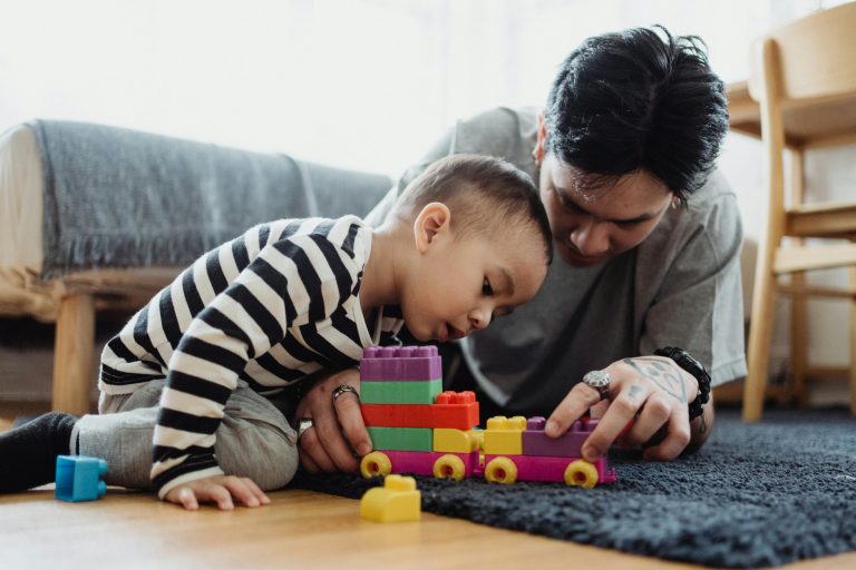 Parent helping a child clean up toys at home