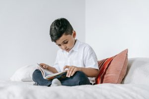Child reading quietly at home with parental support