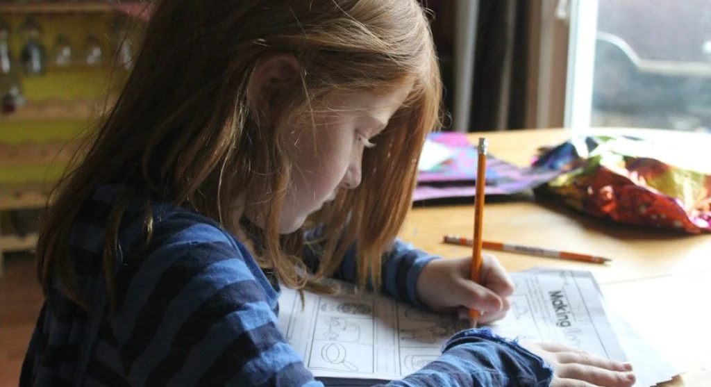 kid doing homework at desk