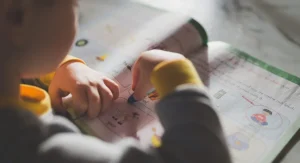 Child circling the action word in worksheet directions before beginning work