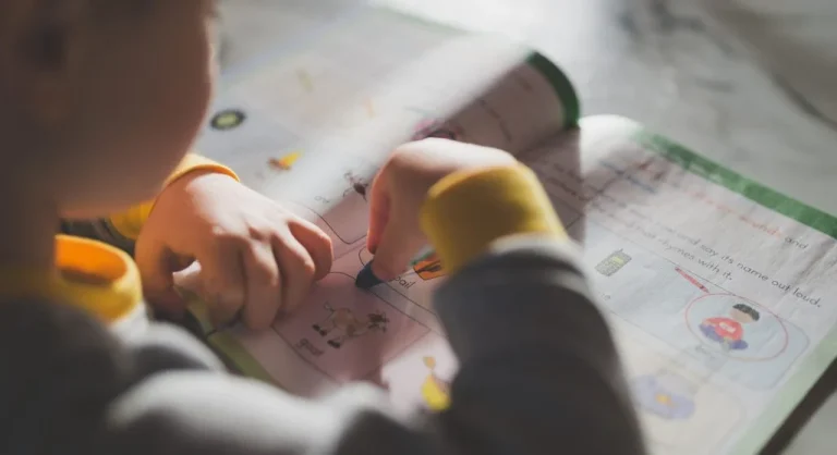 Child circling the action word in worksheet directions before beginning work