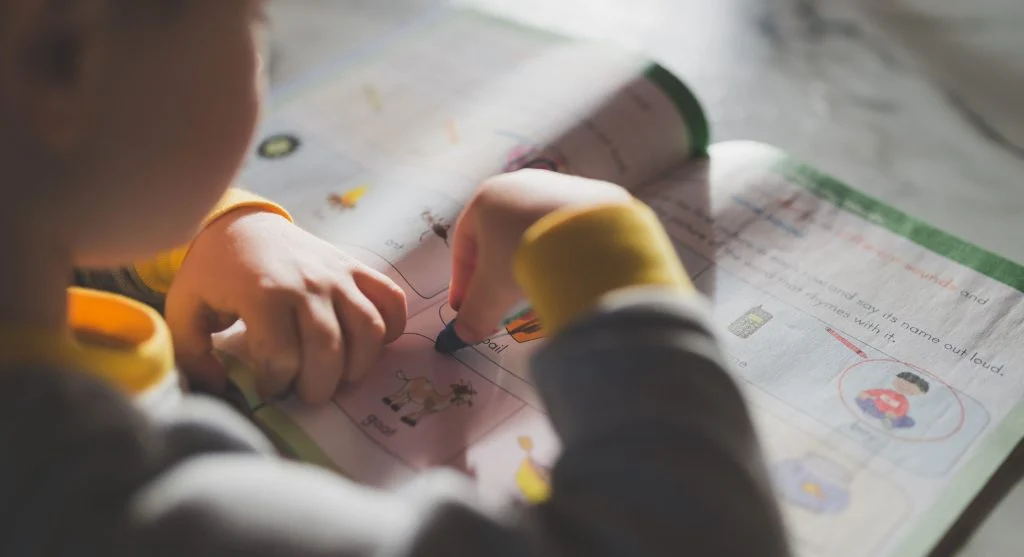 Child circling the action word in worksheet directions before beginning work