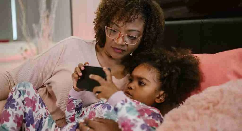 Parent placing a real-world item in a child’s hands before ending shared screen time