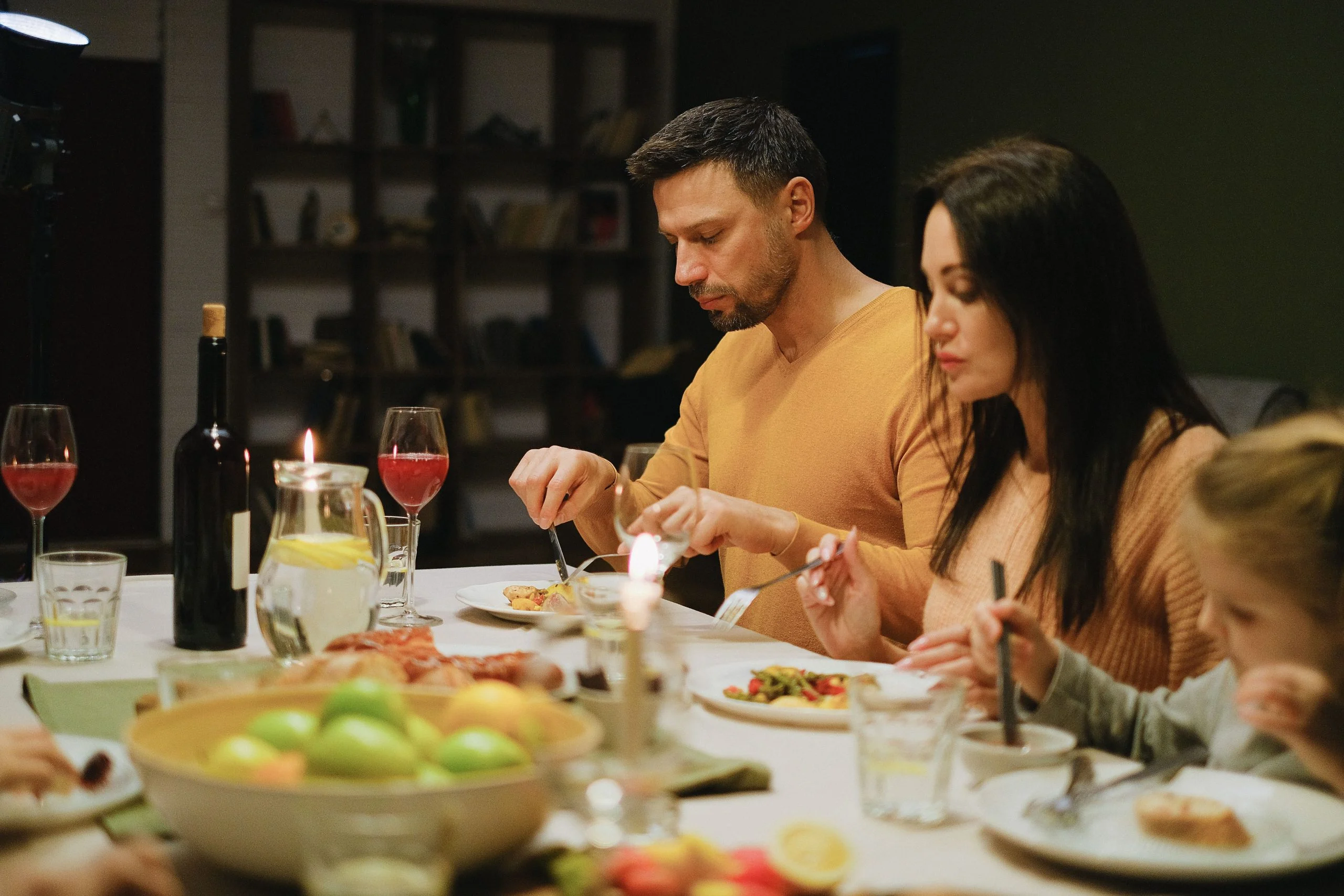 Family eating dinner together with devices stored in a basket nearby