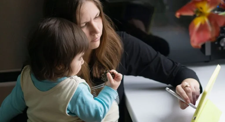 Parent and child placing a tablet on its regular charger after screen time