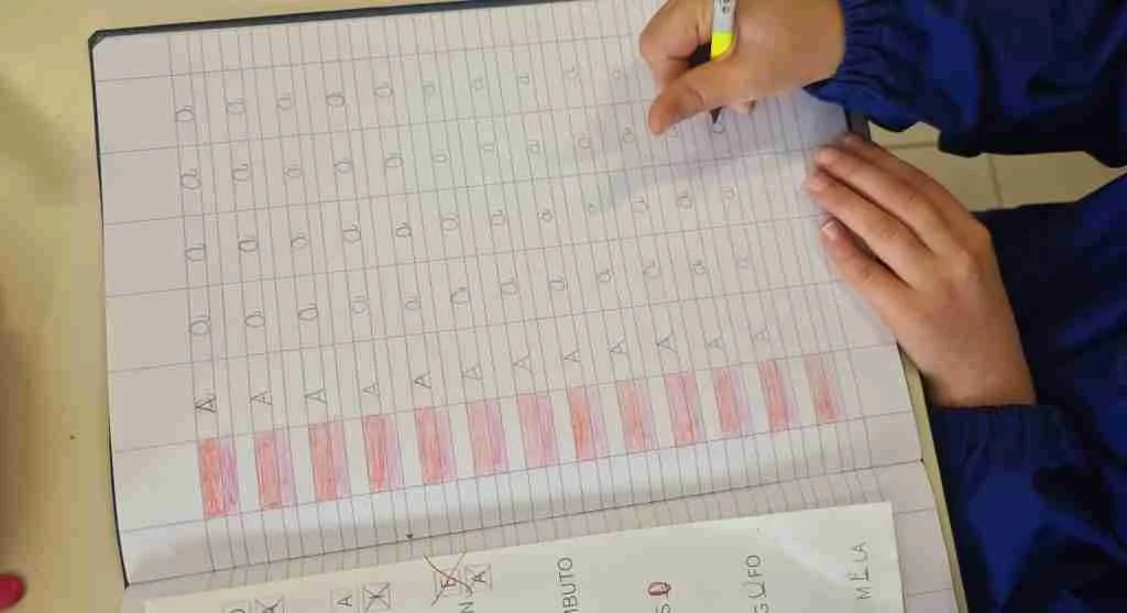 Parent guiding handwriting practice with a model letter above the writing line