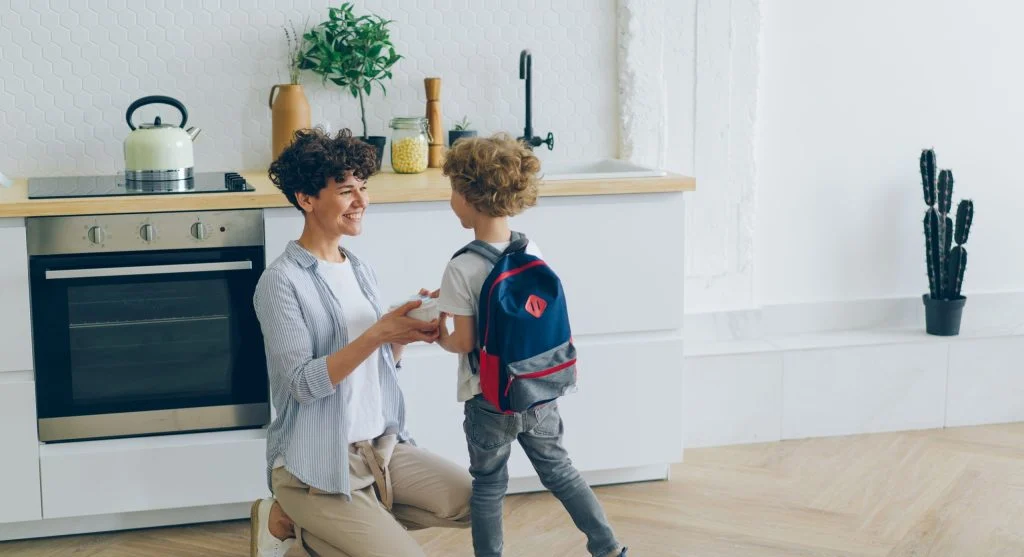 Child’s ready spot near the door with shoes, bag, and bottle placed together