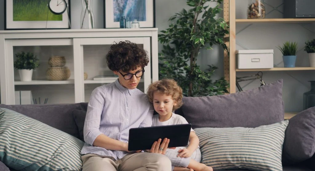Parent helping a child end a video at a natural scene change at home
