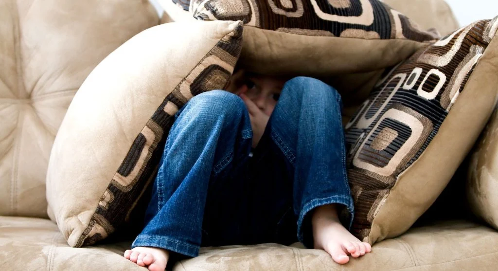 Child holding tightly to a favorite toy during an emotionally heavy moment at home
