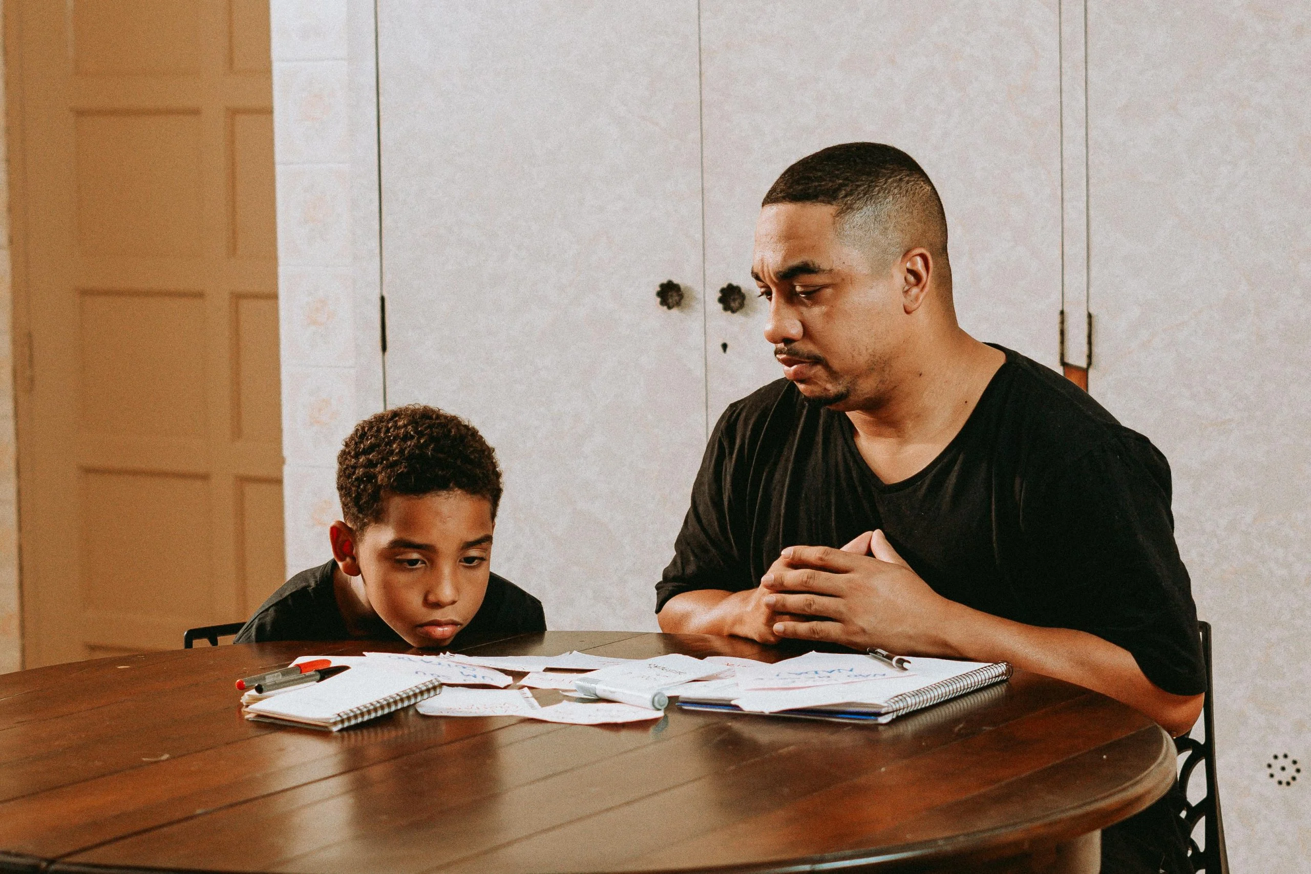Parent helping with one small part of a child’s task while the child stays involved