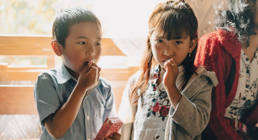 Siblings taking different roles in a shared family tradition at home
