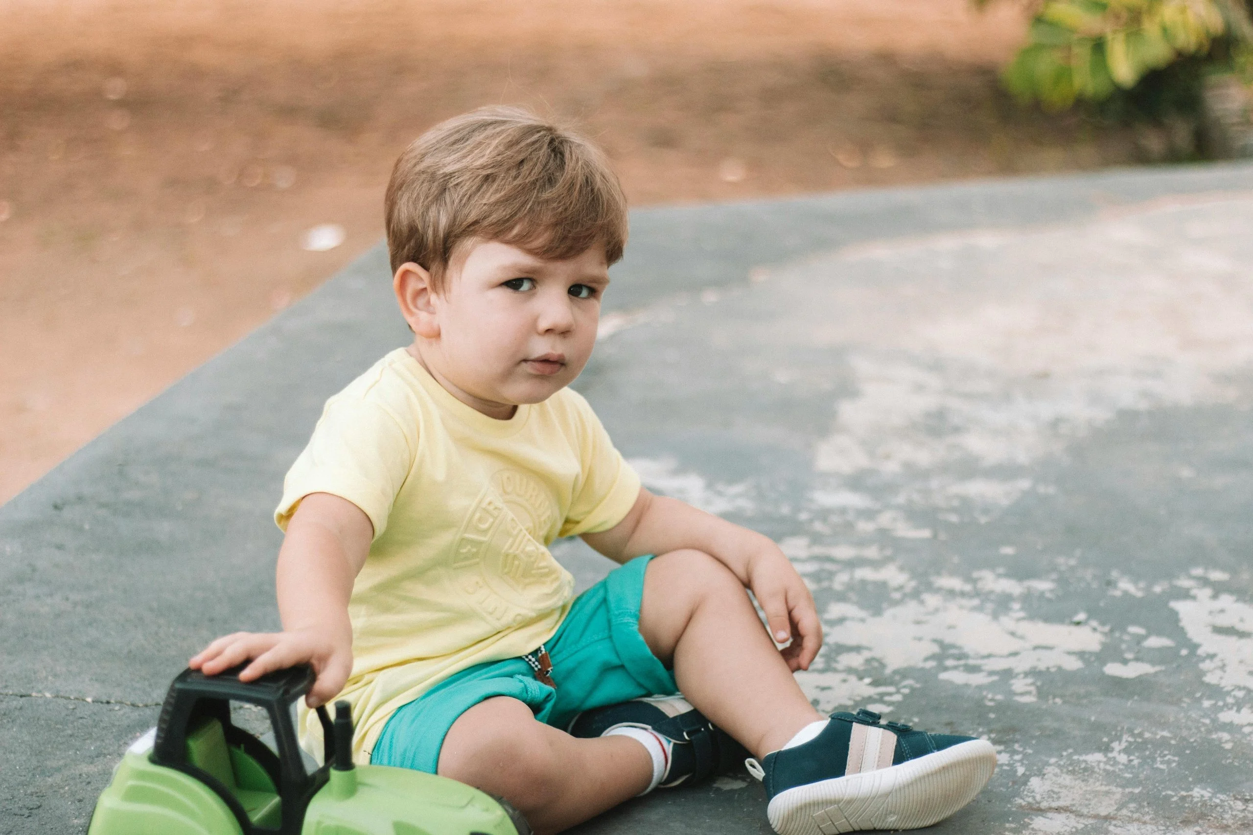 kid resting outside with toys