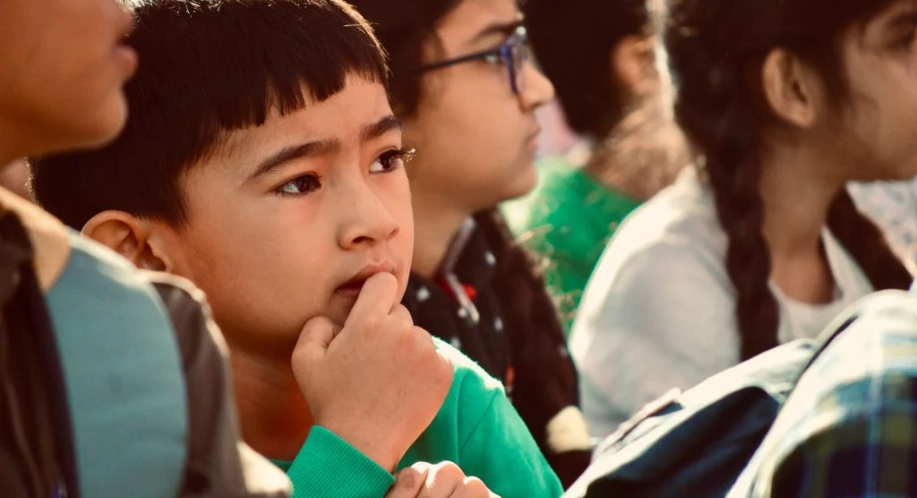 Child quietly observing a group before joining