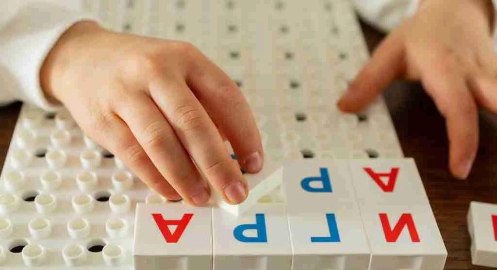 Child independently copying letters with the model placed above the line