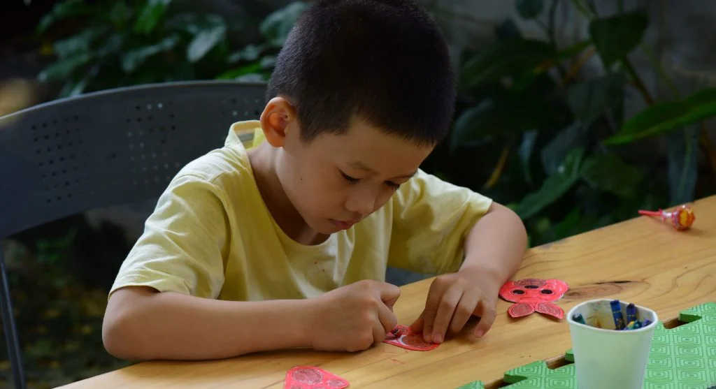 Child focusing on a craft step with only one supply visible