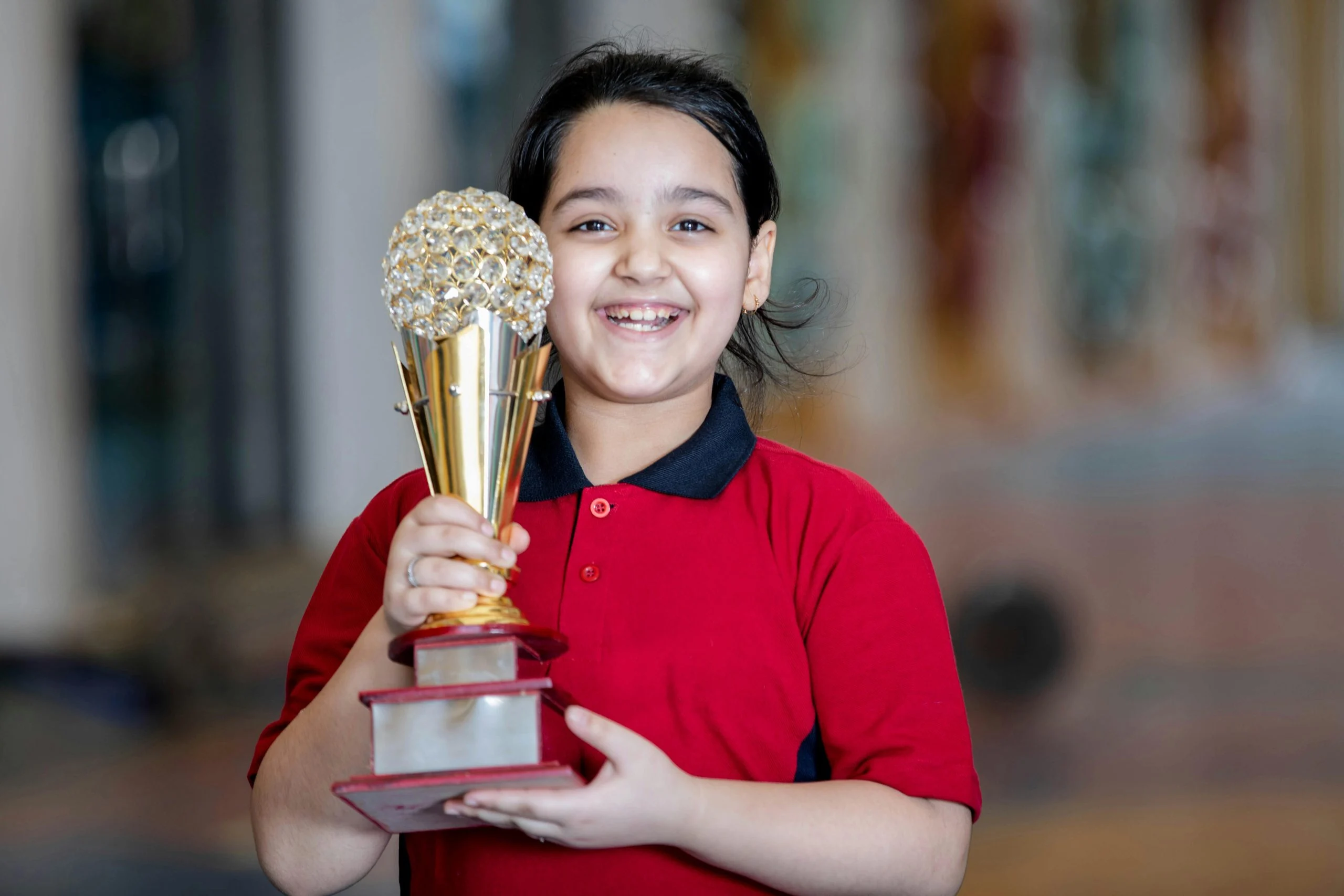 happy child holding trophy and certificate