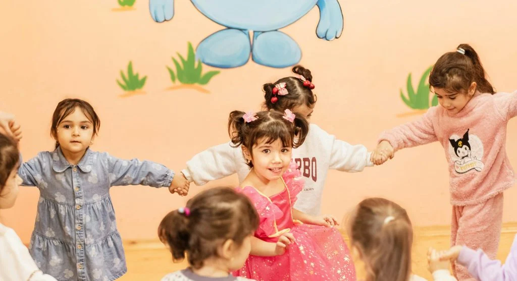 adult helping kids take turns playing