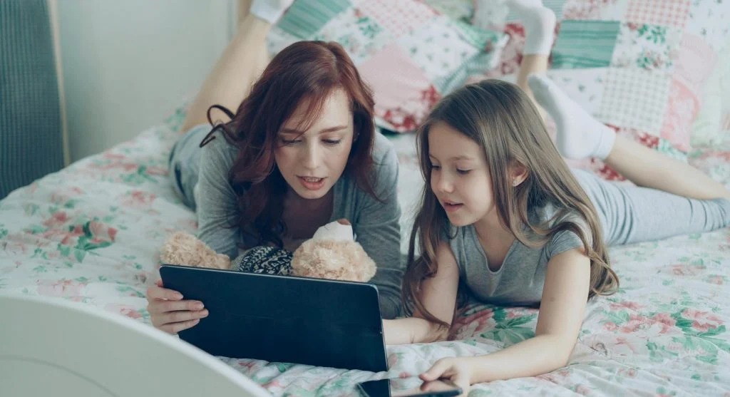 Parent helping children switch turns calmly on a shared device