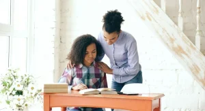 Parent calmly offering help to a child during a difficult task at home