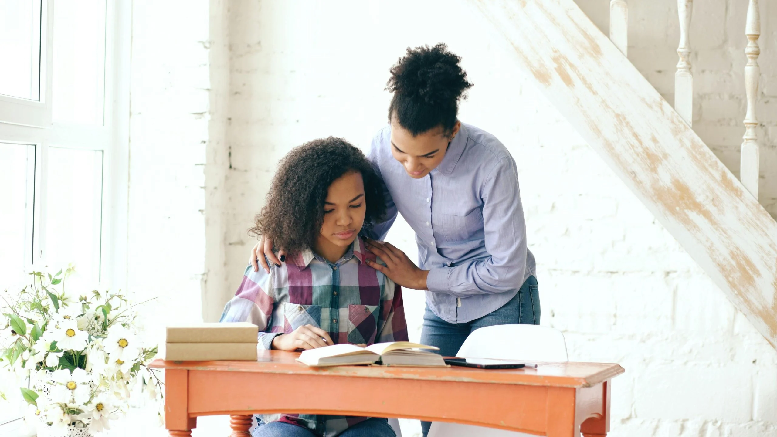 Parent calmly offering help to a child during a difficult task at home