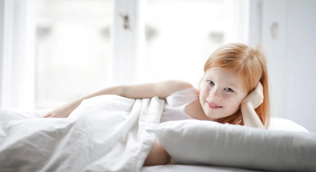 happy kids waking up in bed