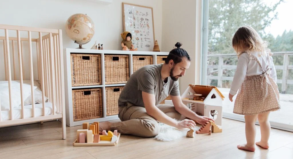 Child putting toys into a clearly identified cleanup basket at home
