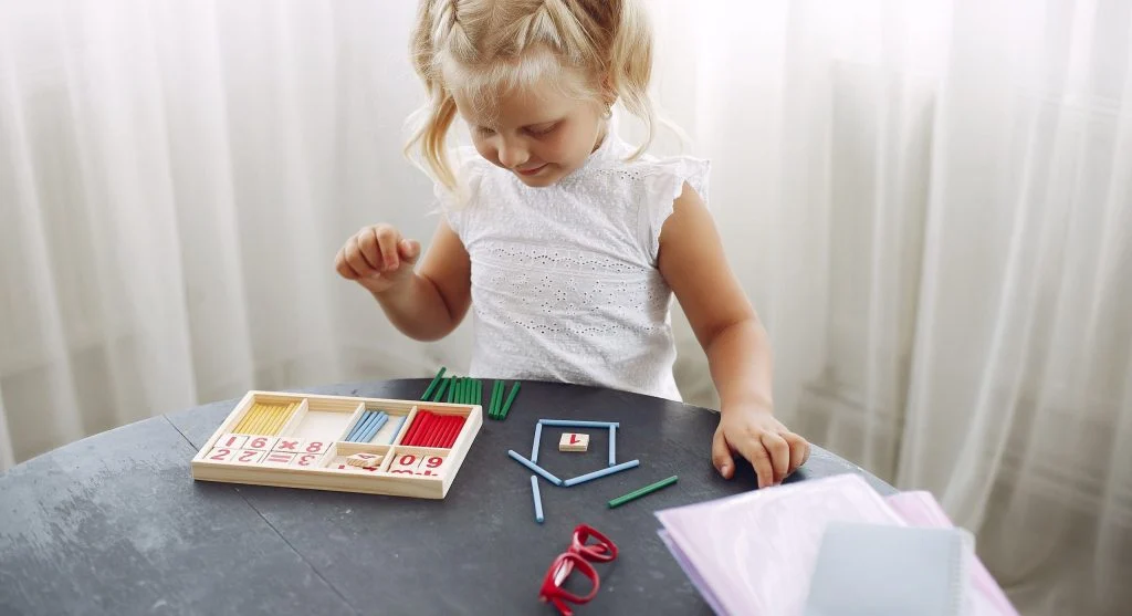 Child learning with everyday objects before starting written practice at home