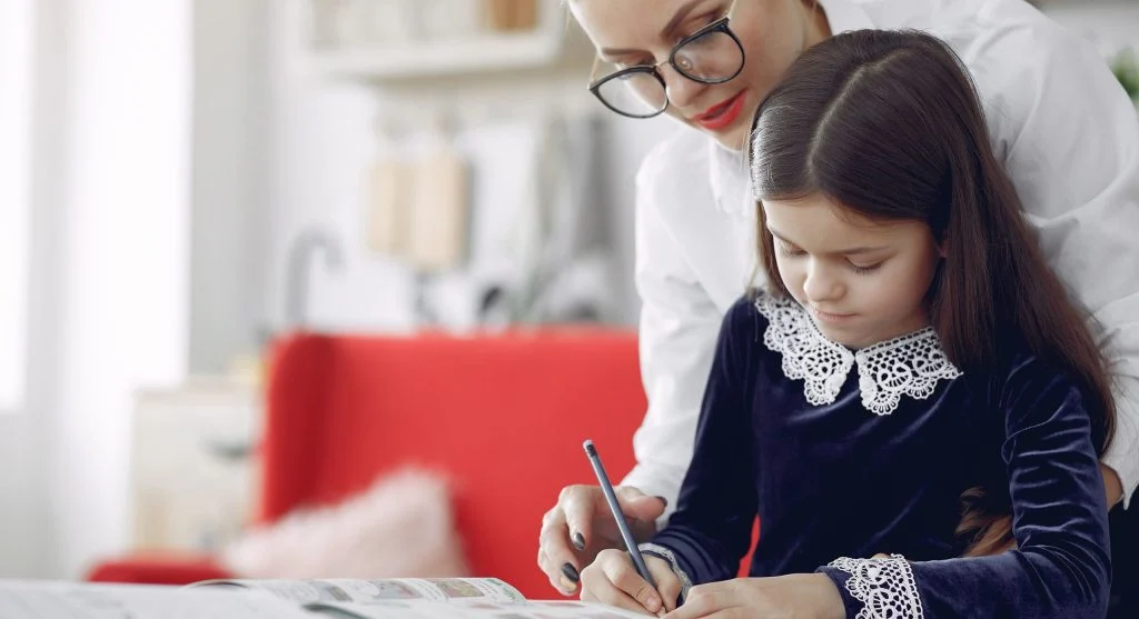 Parent giving a child a starter line for writing practice at home