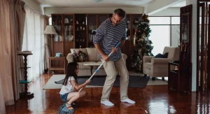 Parent showing a child the finished cleanup spot before tidying begins
