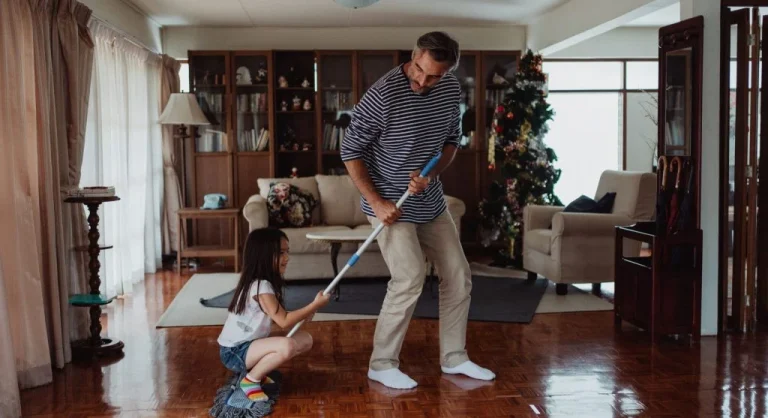 Parent showing a child the finished cleanup spot before tidying begins