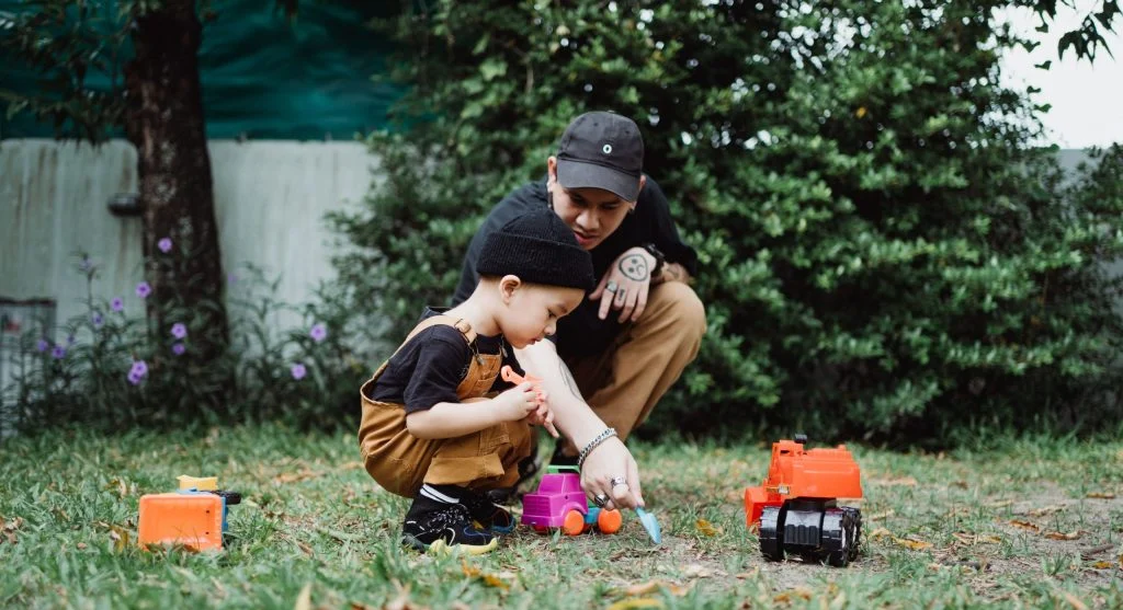 Parent calmly guiding a child through a sharing moment during play