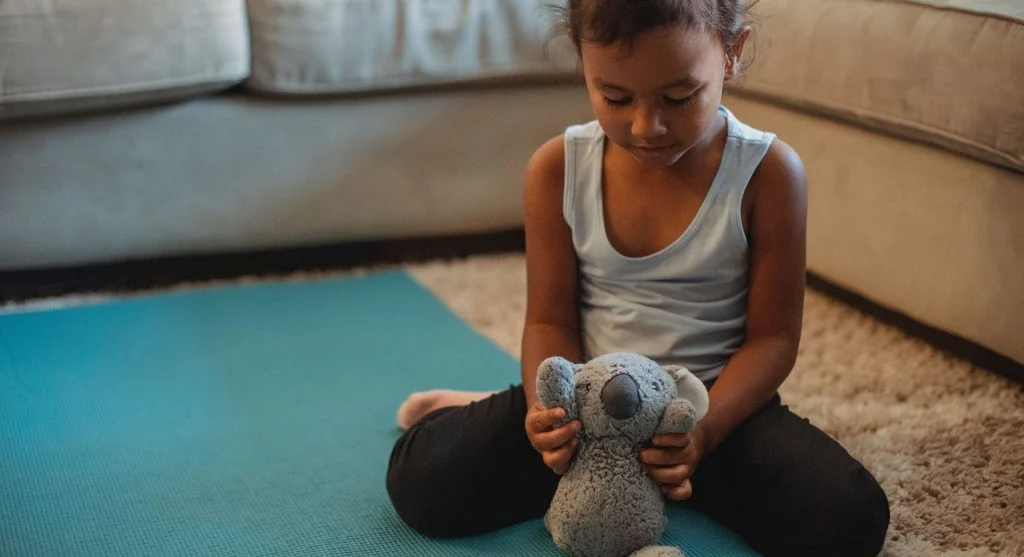 Child holding a favorite belonging closely during a calm moment at home