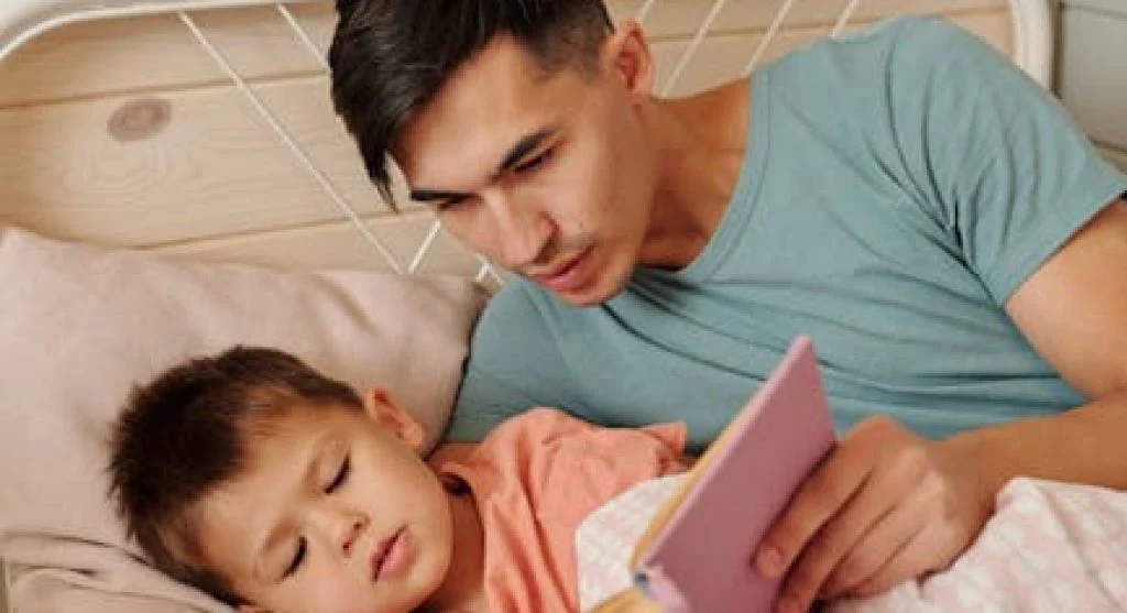 person reading book in bed at night