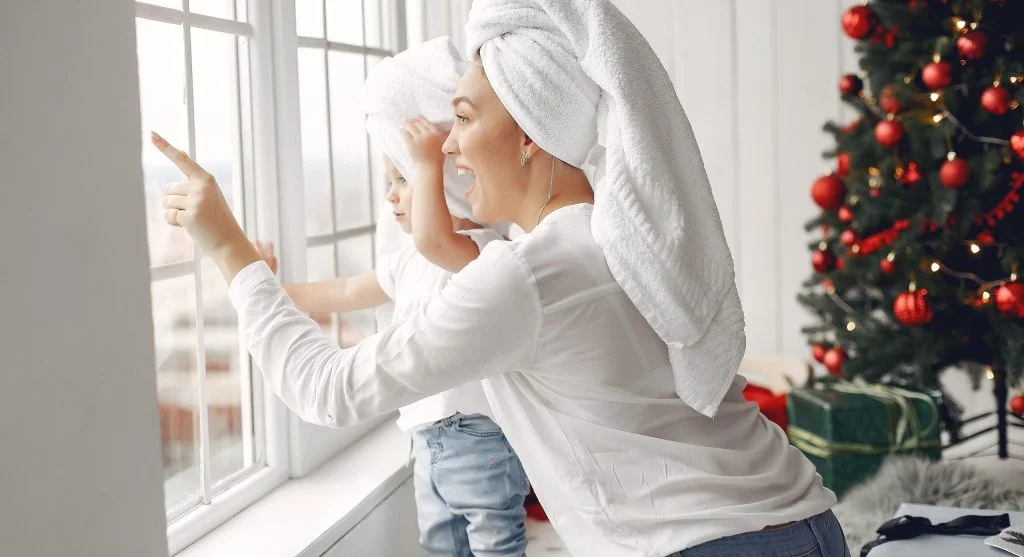 Parent wrapping a child in a warm towel after bath time at home