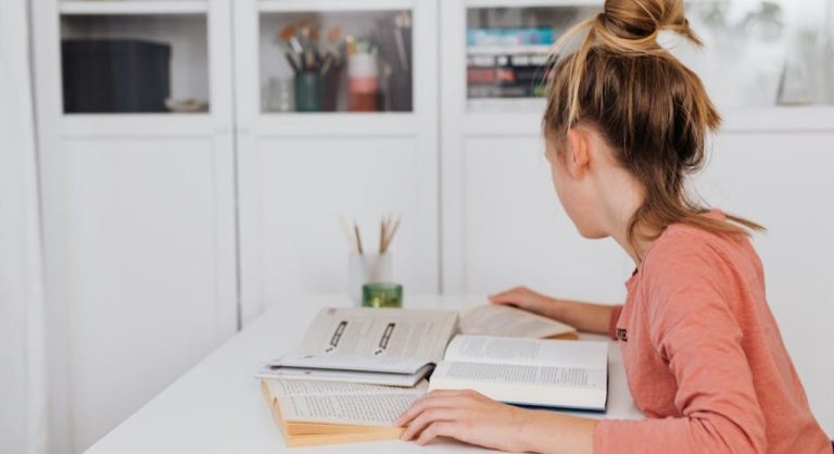 kid reading book at desk