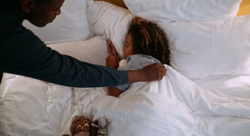 Parent and child completing a gentle final bedtime step together