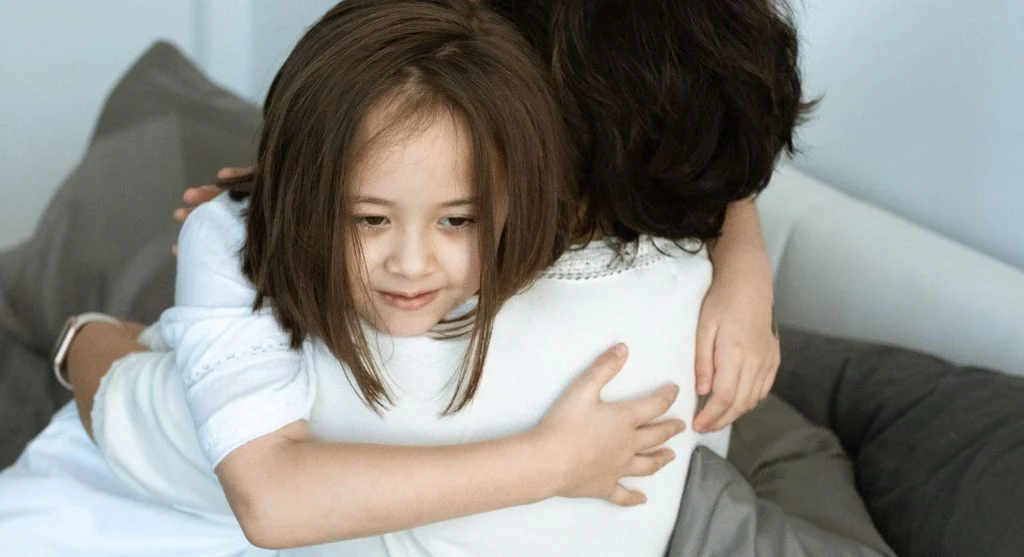 Parent sitting calmly with a child who wants control during play after a hard day