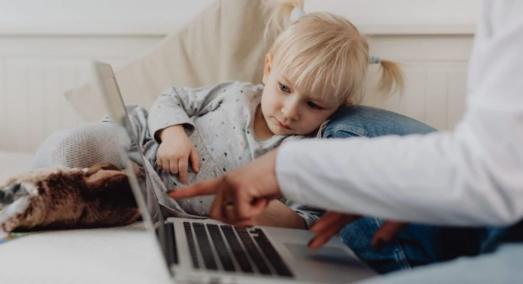 Child helping close a device screen during a calm transition at home