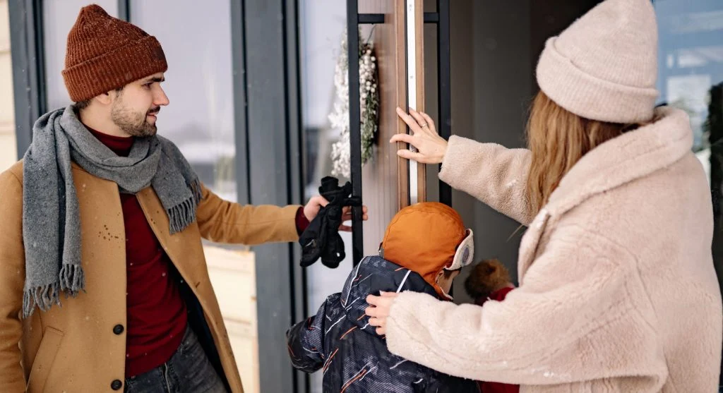 Parent calmly guiding a child toward shoes already set by the door