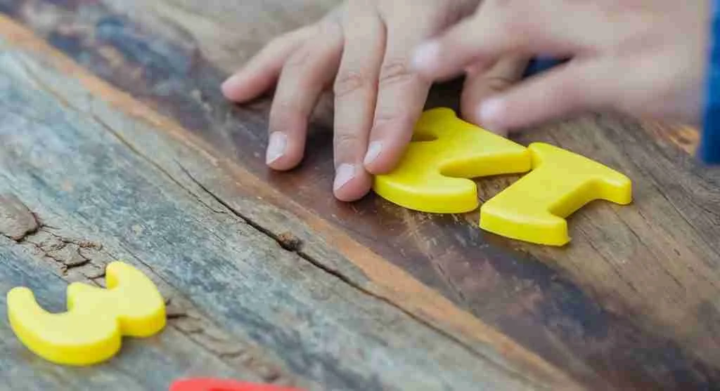 Child counting objects at a table while keeping track of each item