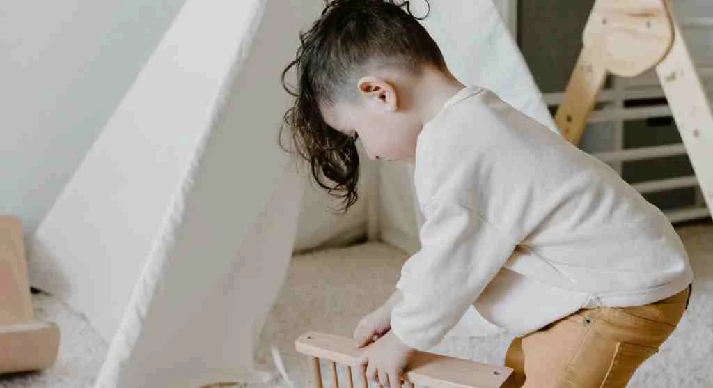Child counting everyday objects by sliding them into a new space at home