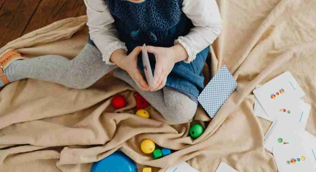 Child pausing to listen before sorting picture cards by beginning sound