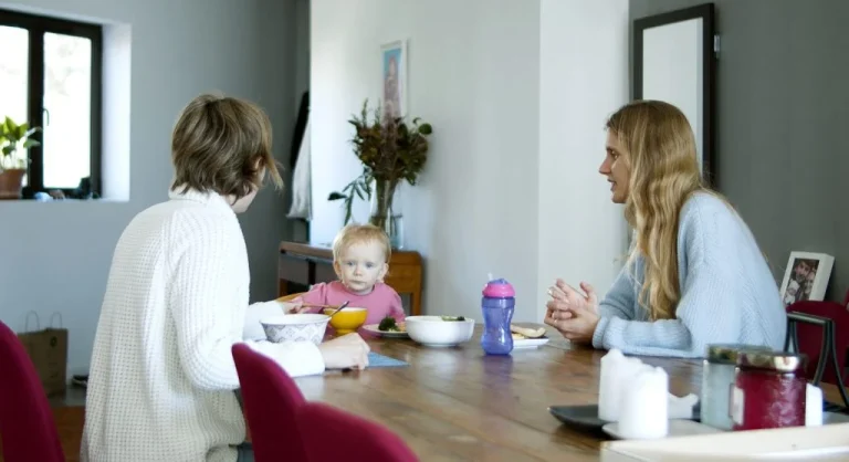 Parent sitting calmly with a child during a quiet conversation at home