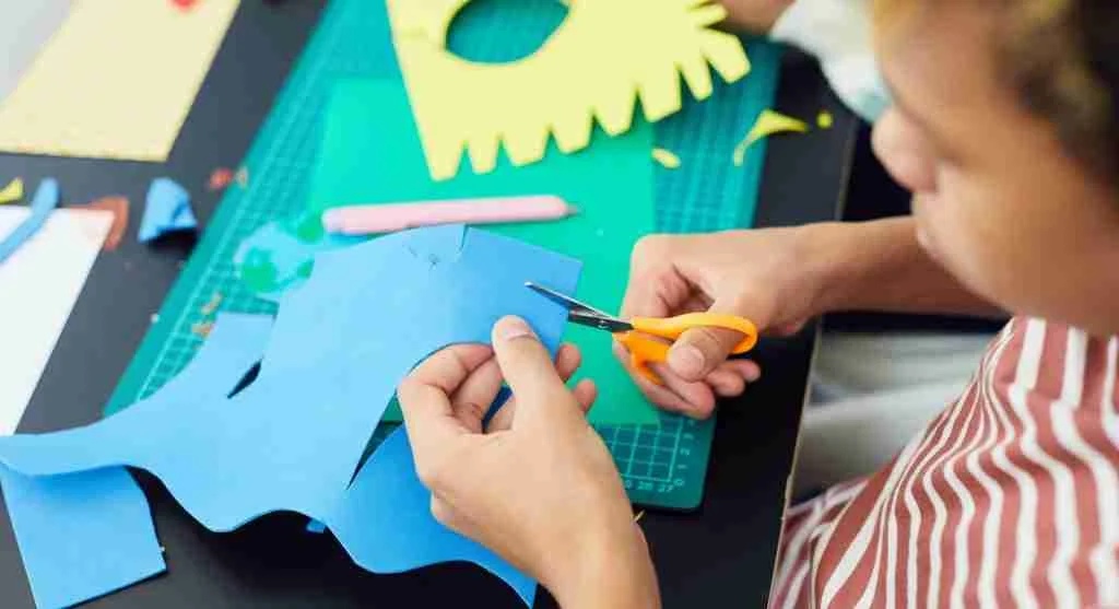 Child practicing a steady cutting rhythm while turning paper at home