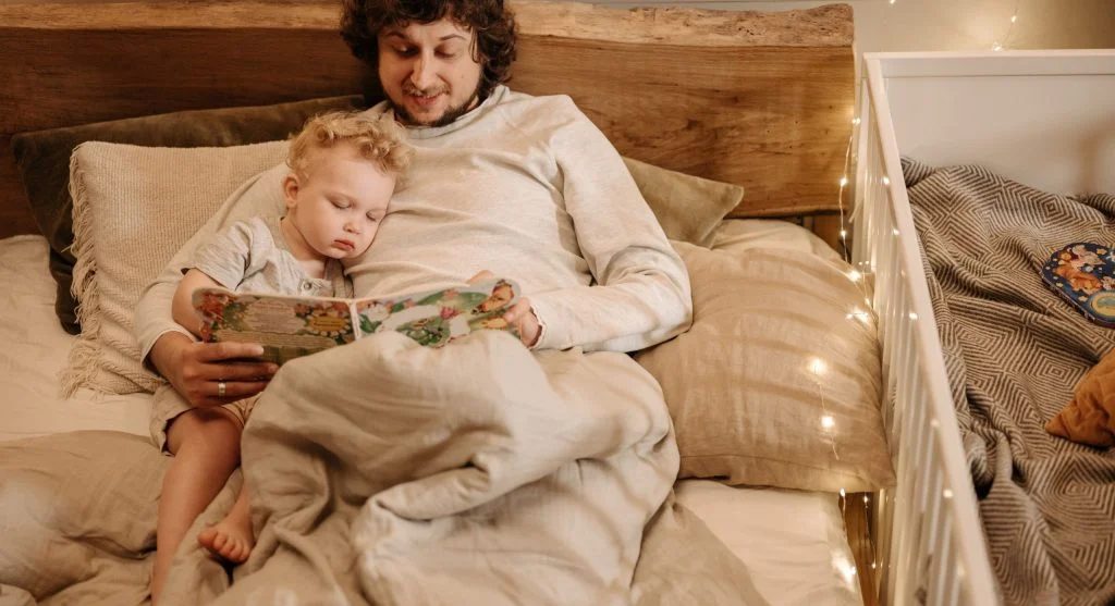 Quiet child resting after a busy day while a parent stays nearby